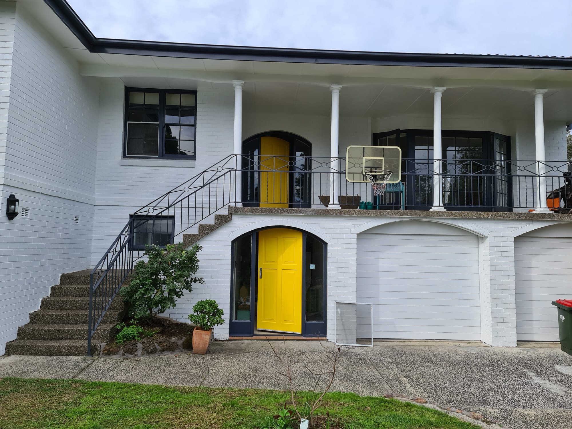 Sydney home freshly repainted in white with bold yellow feature doors by Maestro Painting
